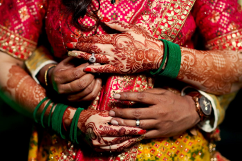 Close-up of bride’s mehndi hands with wedding rings during an Indian destination wedding. Close-up of bride’s mehndi hands with wedding rings during an Indian destination wedding.