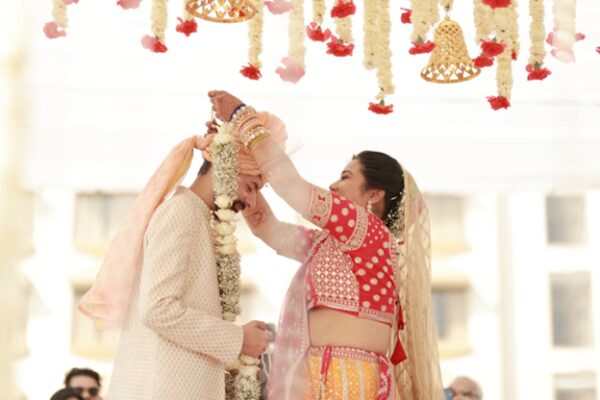 Bride placing garland on groom during a traditional Indian wedding ceremony in Cancun at a luxury resort.