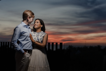 Ummae and Ryan sharing a sunset portrait during their Indian destination wedding celebration with colorful sky in the background