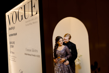 Ummae and Ryan posing inside a Vogue magazine cover–inspired photo booth at their sangeet during an Indian destination wedding celebration

Caption: Ummae and Ryan strike a pose inside their Vogue-inspired sangeet photo booth, turning wedding memories into a magazine-worthy moment.