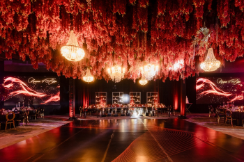 Indian destination wedding reception at Dreams Bahia Mita with cascading red floral ceiling, crystal chandeliers, and illuminated dance floor in Riviera Nayarit, Mexico
