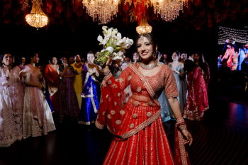 Ummae holding her bouquet on the dance floor during the reception bouquet toss at her Indian destination wedding celebration
