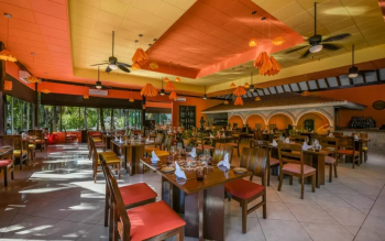 Interior of Rincón Mexicano restaurant at El Dorado Royale, offering international à la carte breakfast and Mexican cuisine in a warm tropical dining setting. Interior of Rincón Mexicano restaurant at El Dorado Royale, offering international à la carte breakfast and Mexican cuisine in a warm tropical dining setting.