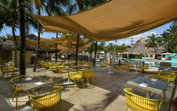 Outdoor seating area at La Cabaña Pizzería at El Dorado Royale featuring poolside dining, shaded lounge seating, and a relaxed tropical atmosphere. AAAAAAAAAAAAAAAAAAAAAAAA