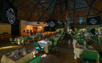 Interior of Fuentes Culinary Theatre featuring upscale dining tables, dramatic lighting, and an immersive show cooking experience with gourmet cuisine. Interior of Fuentes Culinary Theatre featuring upscale dining tables, dramatic lighting, and an immersive show cooking experience with gourmet cuisine.