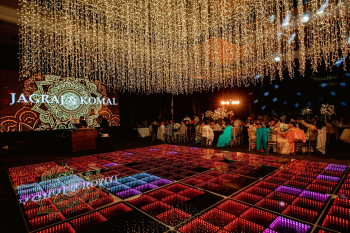 Grand Ballroom wedding reception for Komal and Jagraj featuring dramatic ceiling lighting, illuminated dance floor, large LED screen, and elegant Indian wedding décor. Grand Ballroom wedding reception for Komal and Jagraj featuring dramatic ceiling lighting, illuminated dance floor, large LED screen, and elegant Indian wedding décor.