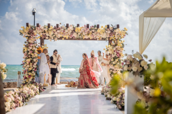Oceanfront Indian wedding ceremony at Beach Gazebo 55 featuring a floral mandap, bride and groom, and turquoise Caribbean water in the background. Oceanfront Indian wedding ceremony at Beach Gazebo 55 featuring a floral mandap, bride and groom, and turquoise Caribbean water in the background.