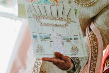 Eshwar holding a custom live painting inspired by the couple’s Hindu wedding ceremony