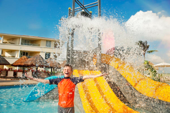 Child playing in a resort kids pool with water slides and splash features designed for family-friendly fun