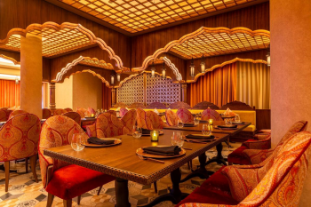 Interior of Agra restaurant featuring elegant Indian-inspired design, carved arches, warm lighting, and table settings for a refined dining experience