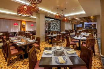 Interior of Los Caporales restaurant with warm lighting, wooden tables, and traditional design elements for a Mexican dining experience