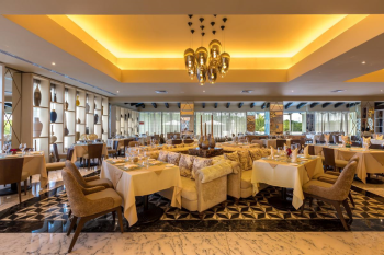 Elegant interior of Trattoria restaurant with modern décor, warm lighting, and neatly arranged dining tables in a relaxed setting