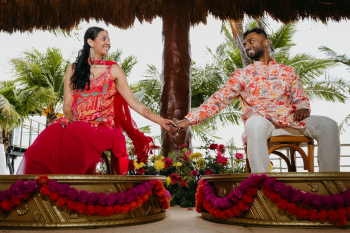 Wedding guests dance beneath colorful 
class=SpellE>papel picado banners and string lights during the sangeet
celebration.