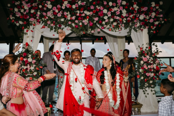 Katherine and Marun celebrate beneath their
floral mandap as guests shower them with flower petals following their Hindu
wedding ceremony.