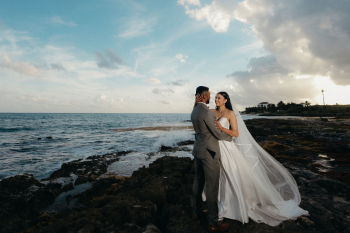 Katherine and Marun embrace along the rocky
Caribbean shoreline during sunset wedding portraits.