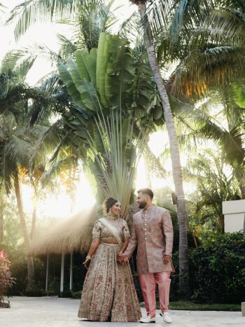 Meha and Gilbert walk hand in hand through
the tropical grounds of Generations Riviera Maya before their welcome dinner at
the White Gazebo, dressed in coordinated cream and blush Indian wedding attire. Meha and Gilbert walk hand in hand through
the tropical grounds of Generations Riviera Maya before their welcome dinner at
the White Gazebo, dressed in coordinated cream and blush Indian wedding attire.