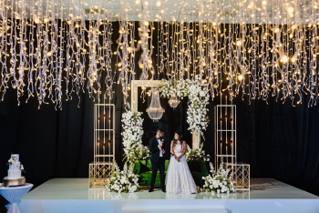 Ripal and Palak at their Indian wedding reception stage with floral decor and hanging lights at Generations Riviera Maya