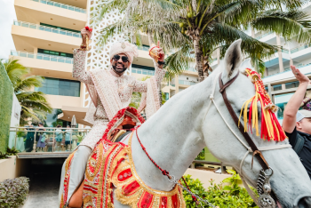Indian wedding baraat at Generations Riviera Maya, featuring groom Palak arriving on horseback during a traditional South Asian wedding procession through the resort. Indian wedding baraat at Generations Riviera Maya, featuring groom Palak arriving on horseback during a traditional South Asian wedding procession through the resort.