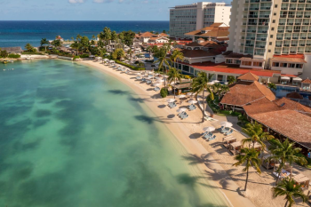 Aerial view of Moon Palace Jamaica's beachfront with turquoise water, palm trees, and oceanfront event space, a stunning setting that suits some Indian destination weddings better than others. Aerial view of Moon Palace Jamaica's beachfront with turquoise water, palm trees, and oceanfront event space, a stunning setting that suits some Indian destination weddings better than others.