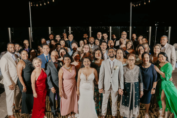 Couple posing in a group shot at the end of their wedding reception during an Indian destination wedding. Couple posing in a group shot at the end of their wedding reception during an Indian destination wedding.