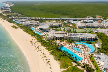 Aerial view of Moon Palace The Grand Cancun with upscale pools, beachfront, and luxury resort buildings Aerial view of Moon Palace The Grand Cancun with upscale pools, beachfront, and luxury resort buildings
