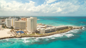 Aerial view of Hyatt Ziva Cancun on a peninsula with ocean views on multiple sides and beachfront resort buildings Aerial view of Hyatt Ziva Cancun on a peninsula with ocean views on multiple sides and beachfront resort buildings