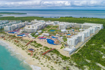 Aerial view of Planet Hollywood Cancun with beachfront pools, resort buildings, and colorful activity areas Aerial view of Planet Hollywood Cancun with beachfront pools, resort buildings, and colorful activity areas