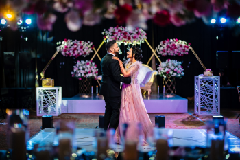 Swathy and Abhishek share their first dance during their Indian destination wedding reception at Moon Palace Cancun, surrounded by elegant floral décor and a beautifully designed ballroom in Mexico. Swathy and Abhishek share their first dance during their Indian destination wedding reception at Moon Palace Cancun, surrounded by elegant floral décor and a beautifully designed ballroom in Mexico.