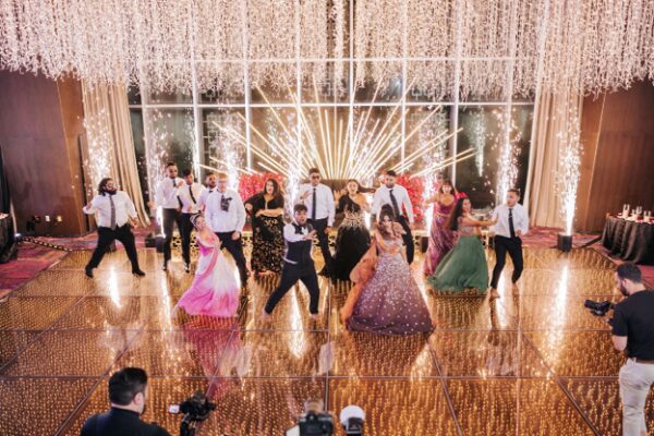 Nina and Avi celebrate with family and friends during their Indian destination wedding reception at Moon Palace The Grand - Cancun, featuring a packed dance floor, dramatic special effects, and luxury reception décor in Mexico.