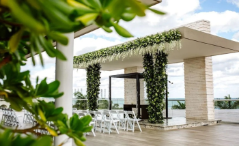 Intimate rooftop wedding venue at Moon Palace The Grand with greenery-covered ceremony structure Intimate rooftop wedding venue at Moon Palace The Grand with greenery-covered ceremony structure