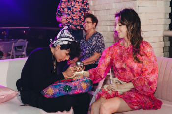 Guest getting henna applied at an Indian wedding Mehndi station in Cancun Guest getting henna applied at an Indian wedding Mehndi station in Cancun