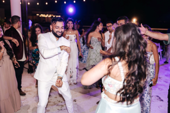 Groom dancing with wedding guests on an outdoor dance floor at an Indian Welcome Night celebration Groom dancing with wedding guests on an outdoor dance floor at an Indian Welcome Night celebration