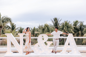 Bride and groom posing beside illuminated N and A marquee letters at an Indian wedding Welcome Night Bride and groom posing beside illuminated N and A marquee letters at an Indian wedding Welcome Night