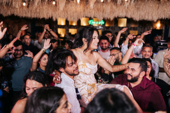 Bride lifted on guests' shoulders during a high-energy Indian wedding Welcome Night celebration Bride lifted on guests' shoulders during a high-energy Indian wedding Welcome Night celebration
