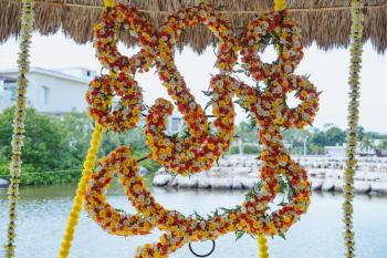 Floral installation hanging from a thatched palapa roof at an Indian wedding Haldi ceremony Floral installation hanging from a thatched palapa roof at an Indian wedding Haldi ceremony