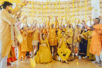 Bride and groom showered with flowers at the end of an Indian wedding Haldi ceremony Bride and groom showered with flowers at the end of an Indian wedding Haldi ceremony