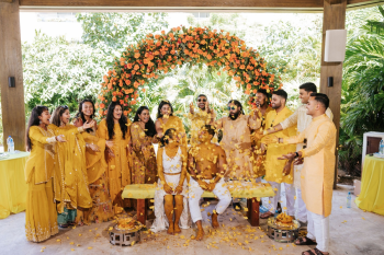 Bride and groom showered with yellow flowers at the close of an Indian wedding Haldi ceremony Bride and groom showered with yellow flowers at the close of an Indian wedding Haldi ceremony