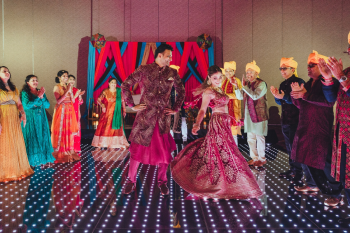 Bride and groom and family performance on a lit dance floor at an Indian Sangeet celebration Bride and groom and family performance on a lit dance floor at an Indian Sangeet celebration