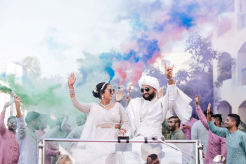 Bride and groom arriving in a vintage-style car for an Indian wedding baraat Bride and groom arriving in a vintage-style car for an Indian wedding baraat