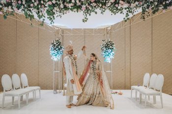 Indoor gold mandap with white and blush florals for an Indian wedding ceremony in a ballroom Indoor gold mandap with white and blush florals for an Indian wedding ceremony in a ballroom