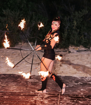 Fire performer entertaining guests at a post-ceremony beach celebration Fire performer entertaining guests at a post-ceremony beach celebration