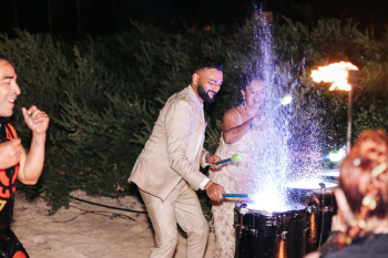 Bride and groom playing on water drums at a post-wedding beach party celebration Bride and groom playing on water drums at a post-wedding beach party celebration
