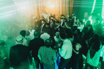 Wedding guests dancing on an LED dance floor surrounded by laser lights and green lighting during an Indian wedding reception Wedding guests dancing on an LED dance floor surrounded by laser lights and green lighting during an Indian wedding reception