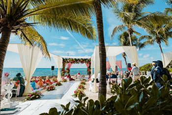Oceanfront ceremony setup with a floral mandap and open-air seating at Generations Riviera Maya, the resort Gurleen and David chose for their Sikh destination wedding in Mexico Oceanfront ceremony setup with a floral mandap and open-air seating at Generations Riviera Maya, the resort Gurleen and David chose for their Sikh destination wedding in Mexico